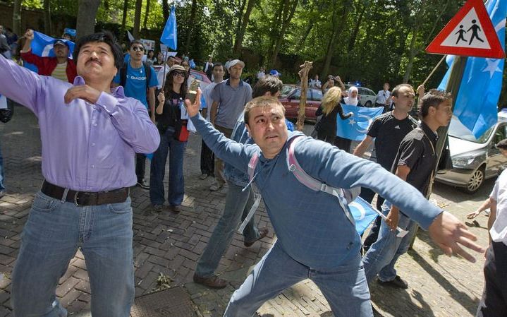 Demonstranten gooien maandag stenen naar de Chinese ambassade in Den Haag. Foto ANP