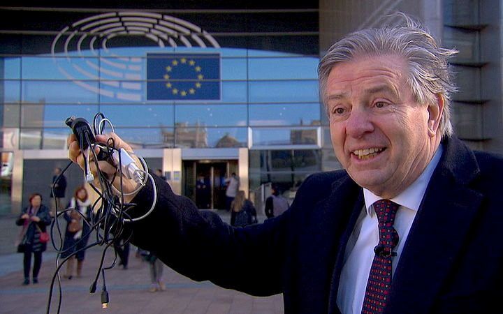 Voormalig Europarlementariër Toine Manders (68) met een hand vol oplaadsnoertjes voor het Europees Parlementsgebouw in Brussel. beeld Toine Manders