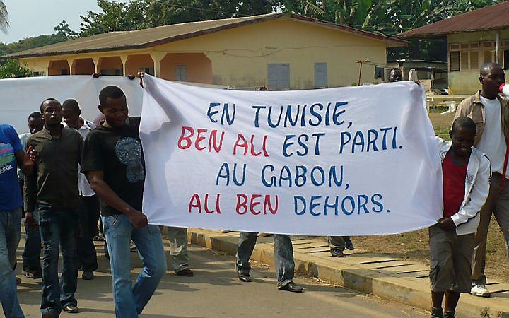 Betoging in Libreville, Gabon. Op het spandoek staat: ”In Tunesië Ben Ali weg, in Gabon Ali Ben erachteraan”. Foto Global Voices Online