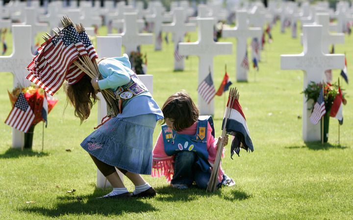 MARGRATEN - Amerikaanse en Nederlandse scouts plaatsen zaterdag op de Amerikaanse begraafplaats in Margraten vlaggen bij de 8301 graven van de soldaten die daar begraven liggen. Foto ANP