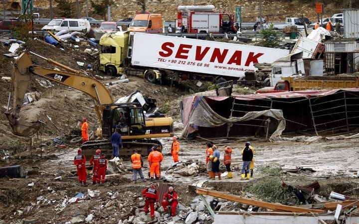 ISTANBUL - Reddingswerkers zijn aan de slag rond vrachtwagentrucks die door een modderstroom van een parkeerplaats zijn weggespoeld. Acht chauffeurs overleden toen ze hier overnachtten en door de overstroming werden overvallen. Foto EPA