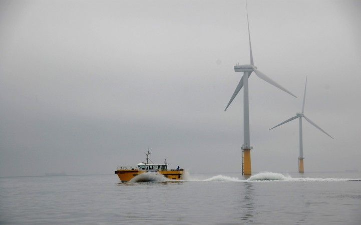 IJMUIDEN – Een werkschip vaart langs enkele windturbines van het woensdag geopende Prinses Amaliawindpark, voor de kust van IJmuiden. Nog niet eerder zijn zo veel windmolens in zulk diep water zo ver uit de kust op de zeebodem gezet. Het maritieme park te