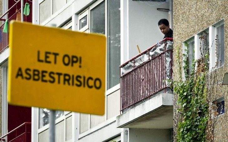 Een bewoner staat op het balkon van de met asbest besmette flat aan de Marco Pololaan in de Utrechtse wijk Kanaleneiland. Foto ANP