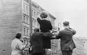 13 augustus 1961, de toenmalige Berlijnse Muur. Inwoners van West-Berlijn zwaaien naar vrienden en familieleden in Oost-Berlijn. Foto AKG