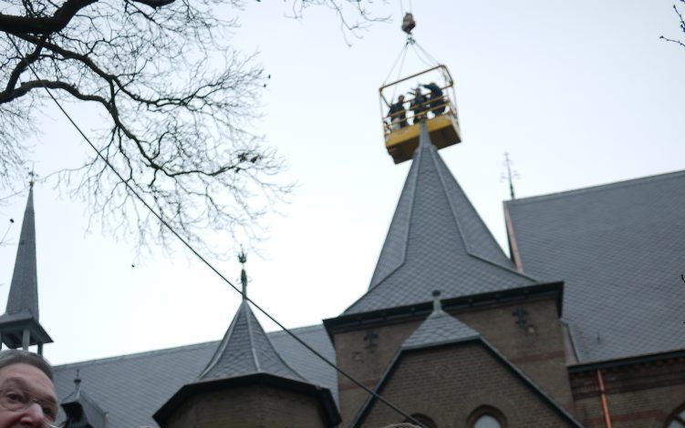 DIEPENVEEN – Broeders van abdij Sion bij Diepenveen kijken toe hoe hun abt met hulp van de Overijsselse gedeputeerde Ranter en een bouwvakker een windvaan op een van de torentjes van de kerk plaatst. Het klooster is gerenoveerd. Foto Michiel Satink