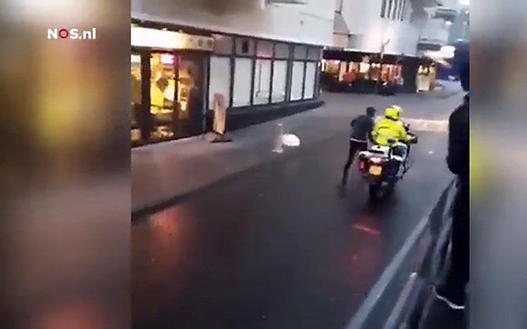 Een motoragent uit Almere heeft een verdachte laten meerennen met zijn motor terwijl hij geboeid was.  beeld video NOS