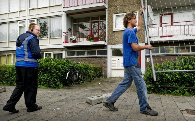 Medewerkers verwijderen hekken bij de met asbest besmette flat aan de Marco Pololaan in de Utrechtse wijk Kanaleneiland. Flatbewoners verbleven tijdelijk elders vanwege asbestvervuiling. Foto ANP