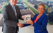 Bakker (r.) overhandigt haar boek aan burgemeester Van Belzen van Barendrecht. beeld meeopdewind.nl
