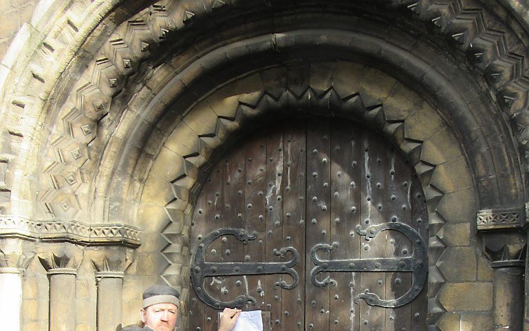 Op de deur van de twaalfde-eeuwse Ronde Kerk in Cambridge (Engeland) werden dinsdag 95 nieuwe stellingen getimmerd. beeld RD