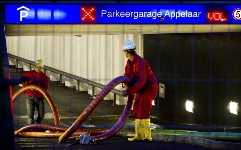 Dikke slangen worden woensdag ingezet om het bluswater dat de brandweer in Haarlem dinsdag gebruikte om de brand in parkeergarage De Appelaar te blussen weer af te voeren. Om het vuur in de ondergrondse garage aan de Damstraat onder controle te krijgen, z