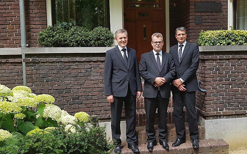 Links kand. H. J. Agteresch, voor het gebouw van de Theologische School in Rotterdam. Naast hem M. Blok en H. E. P. Fortuyn. Alledrie zijn zij inmiddels bevestigd tot predikant. beeld Willem van Cappellen