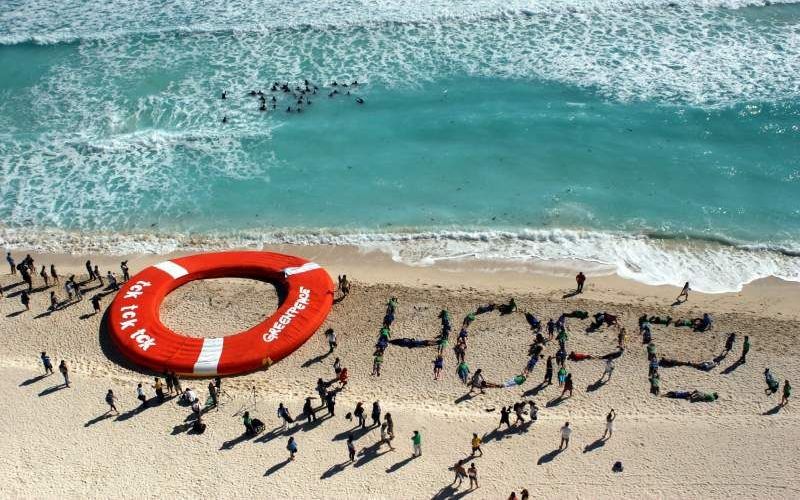 Greenpeace-medewerkers vormen het woord Hope op het strand van Cancun. Foto EPA