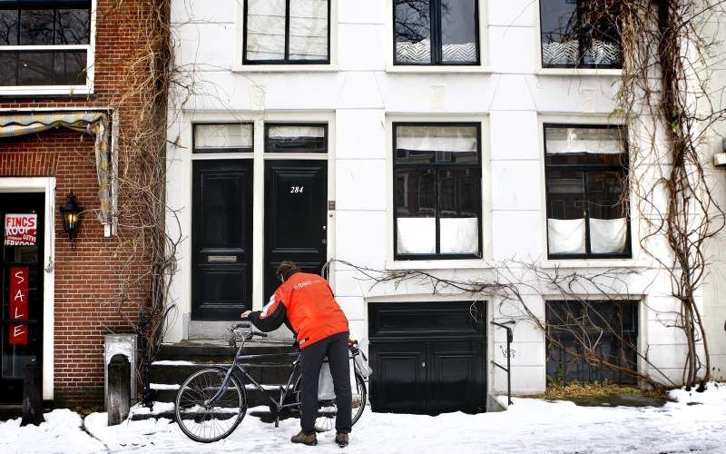 De postbodes van TNT Post zijn na alle acties van de afgelopen weken gisteren weer hard aan het werk gegaan om de achterstand weg te werken. Foto ANP