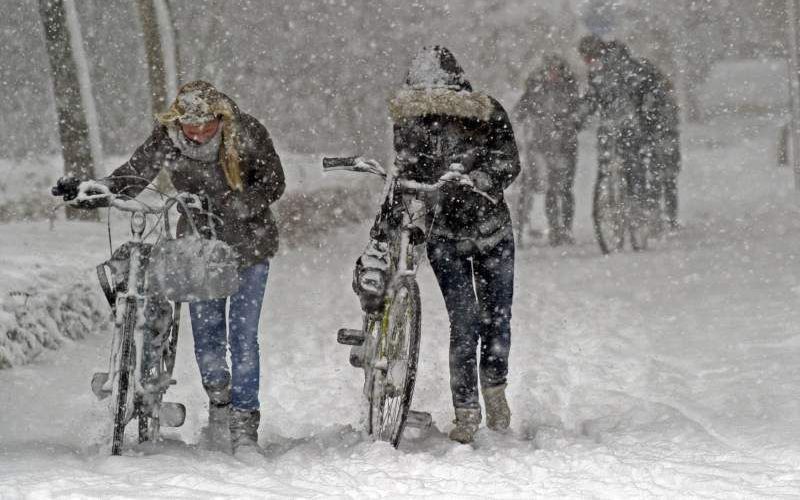 Fietsers stranden vrijdag in een sneeuwstorm in Amstelveen. Foto ANP