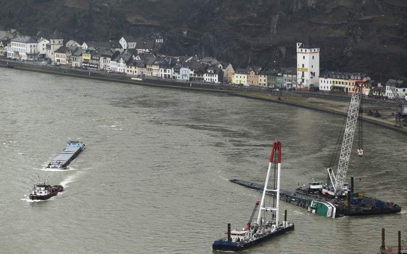 De Duitse Rijkswaterstaat brengt een tweede kraan in positie naast de gekapseisde zuurtanker in de Rijn in Duitsland. Het 105 meter lange schip, geladen met 2400 ton zwavelzuur, blokkeert de doorvaart van circa 200 schepen richting Nederland. De berging z