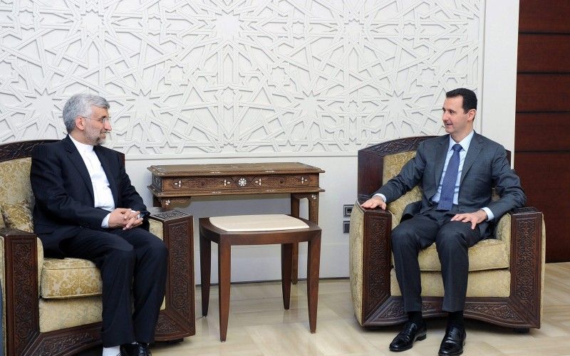 Al-Assad verschijnt na 2 weken weer op tv, in gesprek met de Iraanse gezant Jalili. Foto EPA