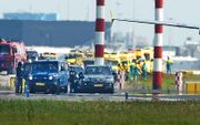 Het arrestatieteam is parraat terwijl passagiers het toestel van de Spaanse luchtvaartmaatschappij Vueling verlaten op Schiphol. Foto ANP