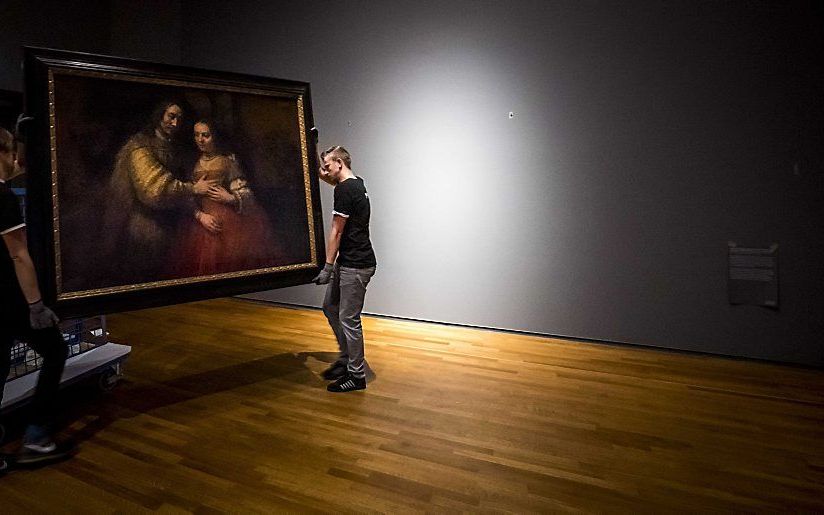 Het schilderij Het Joodse Bruidje van Rembrandt van Rijn wordt opgehangen in het Rijksmuseum, vier dagen voor de publieksopening van de tentoonstelling Alle Rembrandts. Dit jaar is het 350 jaar geleden dat de kunstenaar overleed. beeld ANP