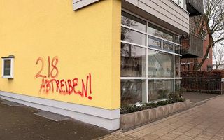 Graffiti op een gele muur.