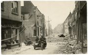 Duitse SS’ers draaien in de meidagen van 1940 de zwaarbeschadigde Hoogstraat in Wageningen in, op weg naar de Grebbeberg. beeld collectie Joost Bruinsma, Soest