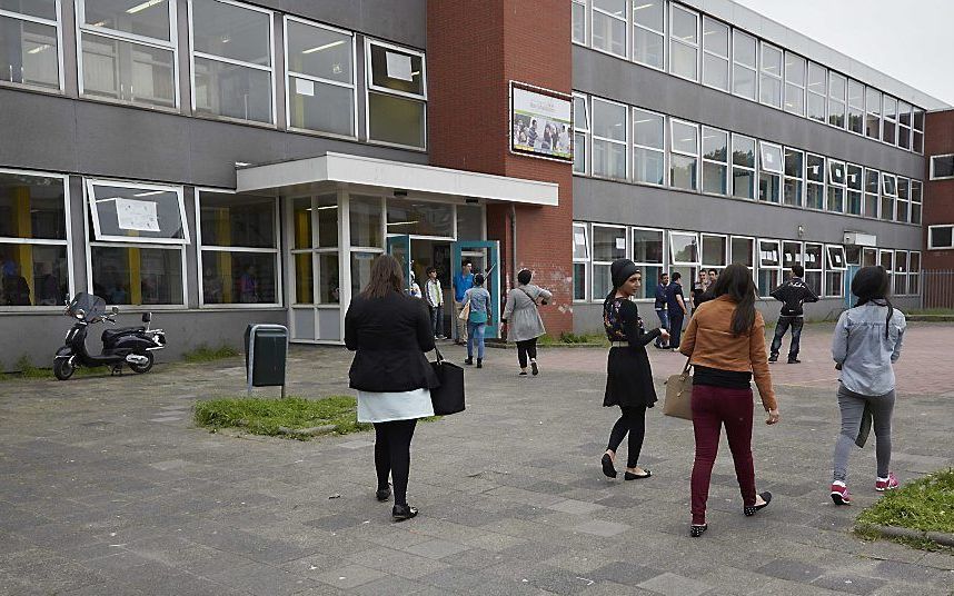 Ouders en leerlingen komen aan bij de Ibn Ghaldoun school voor een informatiebijeenkomst. Foto ANP