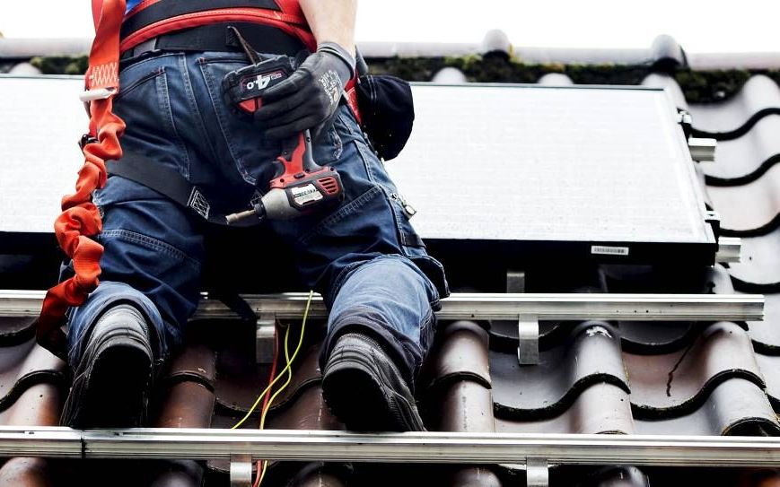 Een monteur plaats zonnepanelen op een woonhuis. Vorig jaar werden in Nederland zo’n 3 miljoen zonnepanelen verkocht. beeld ANP, Koen van Weel