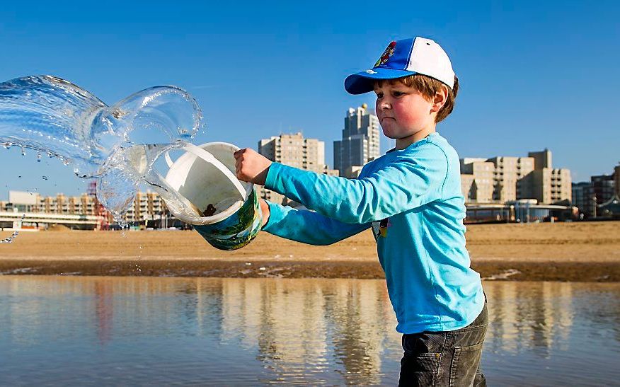 Een jongen speelt woensdag op het strand van Scheveningen. beeld ANP