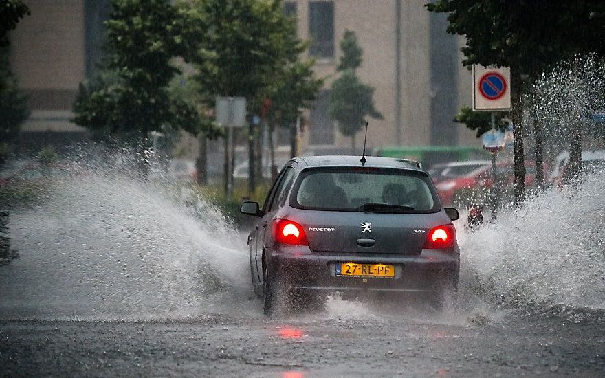 Ondergelopen straten, vastgereden auto’s en overgelopen riolen in het Brabantse Mierlo. De hevige regenval en het noodweer zorgde vorige maand voor veel overlast. beeld ANP, Rob Engelaar