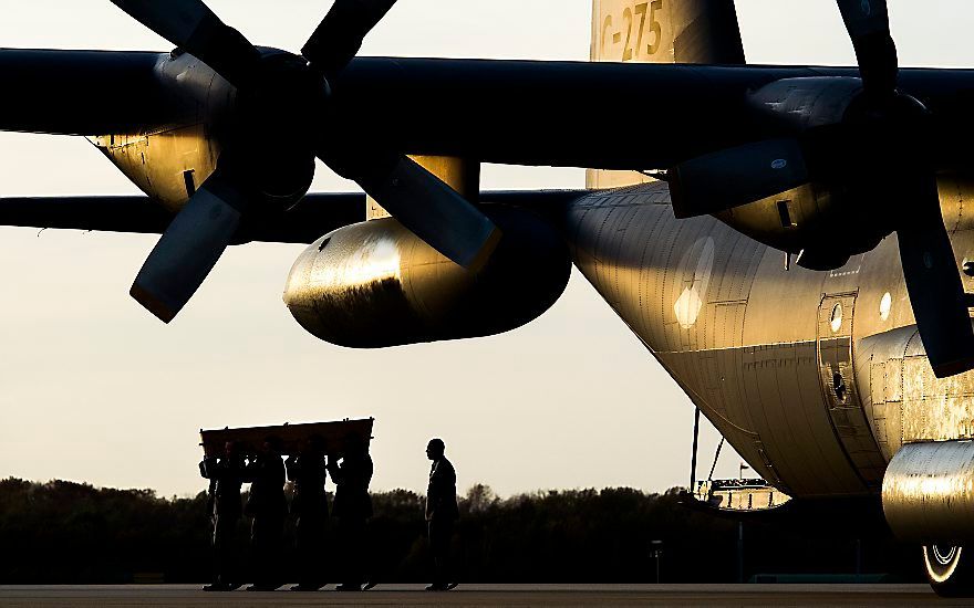 Een van de vijf kisten van de slachtoffers van de vliegramp in Oekraïne wordt uit de Hercules gedragen op vliegbasis Eindhoven. beeld ANP