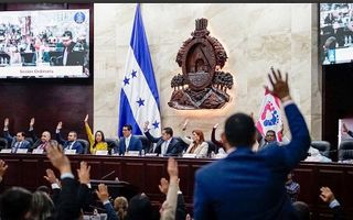 Mensen steken hun handen omhoog tijdens een stemming in het parlementsgebouw van Honduras.