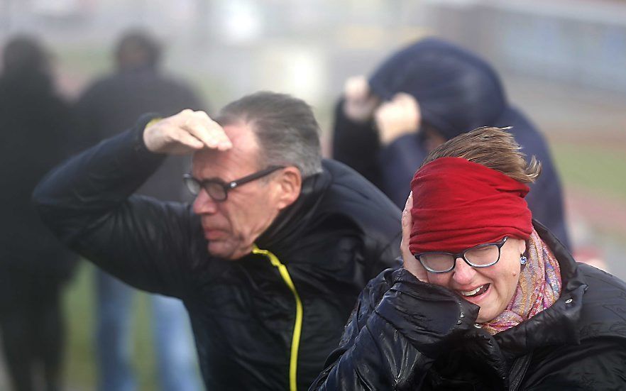 Inwoners van Harlingen worstelen op de zeedijk tegen de storm. beeld ANP