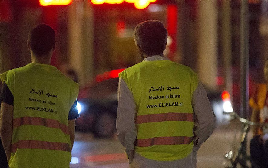 Buurtbewoners in gele hesjes houden de wacht op het Hobbemaplein en grijpen in zodra het onrustig dreigt te worden. beeld ANP