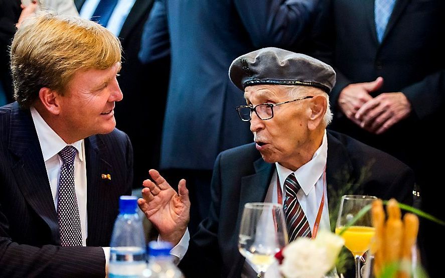 Koning Willem-Alexander is in gesprek met een Poolse veteraan, afgelopen zaterdag in Driel. Beeld ANP