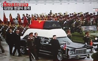Kim Jong-un (m.) salueert bij de kist van zijn vader Kim Jong-il. Foto EPA