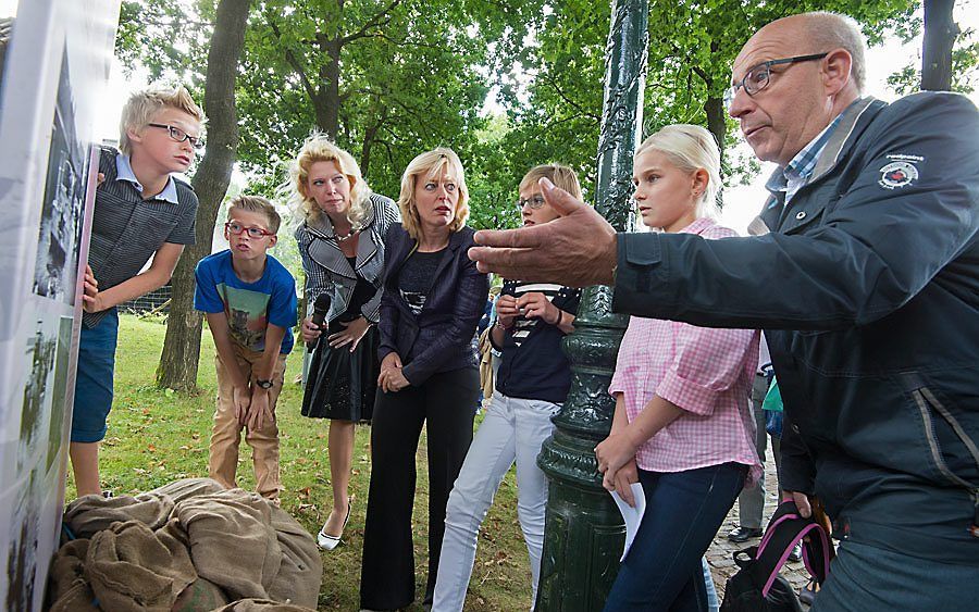 Minister Bussemaker (vierde van l.), burgemeester W. van Hees van de gemeente Geertruidenberg en kinderen uit Raamsdonksveer luisterden maandag in Arnhem naar een oudere Brabander die vertelde over de watersnood van 1953. beeld Nederlands Openluchtmuseum