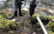 Alison Tune (l.) van de University of Texas, hoofdauteur van de studie, en Brandon Minton (r.), wetenschappelijk medewerker, verzamelen monsters van gesteente bij het Eel River Critical Zone Observatory in de buurt van Elder Creek (VS).  beeld University of Texas, Daniella Rempe