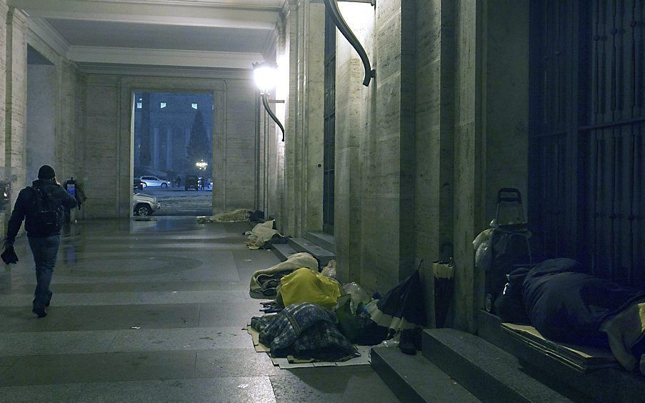 Daklozen slapen onder de colonnades van het Sint-Pietersplein in Rome. beeld EPA