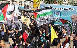 Palestijnen zwaaien met vlaggen en portretten van Abbas, aan de vooravond van de stemming van de Verenigde Naties. Foto EPA