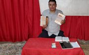 Een Cubaanse predikant toont zijn ontvangen reformatorische bijbelcommentaren. beeld SEZ
