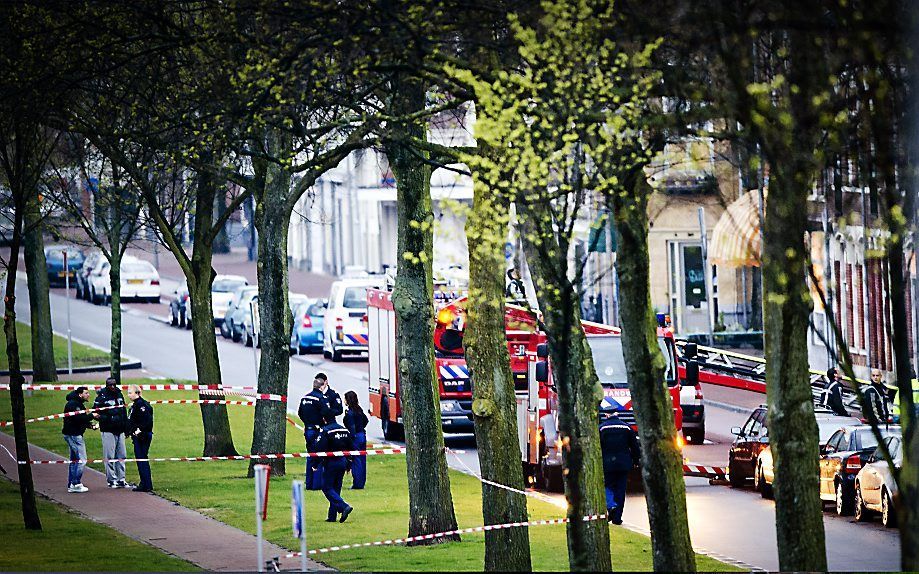 Politieagenten plaatsen afzetlint na een schietpartij in een woning aan de Brede Hilledijk in Rotterdam. Bij het incident zijn twee gewonden gevallen. Foto ANP