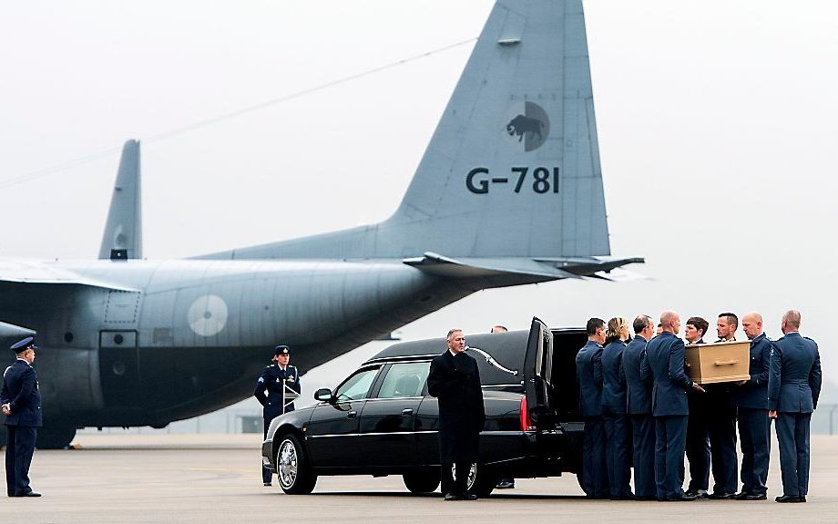 Een lijkkist met resten van de slachtoffers van de vliegramp met vlucht MH17 wordt in een rouwwagen gedragen op vliegbasis Eindhoven. Beeld ANP