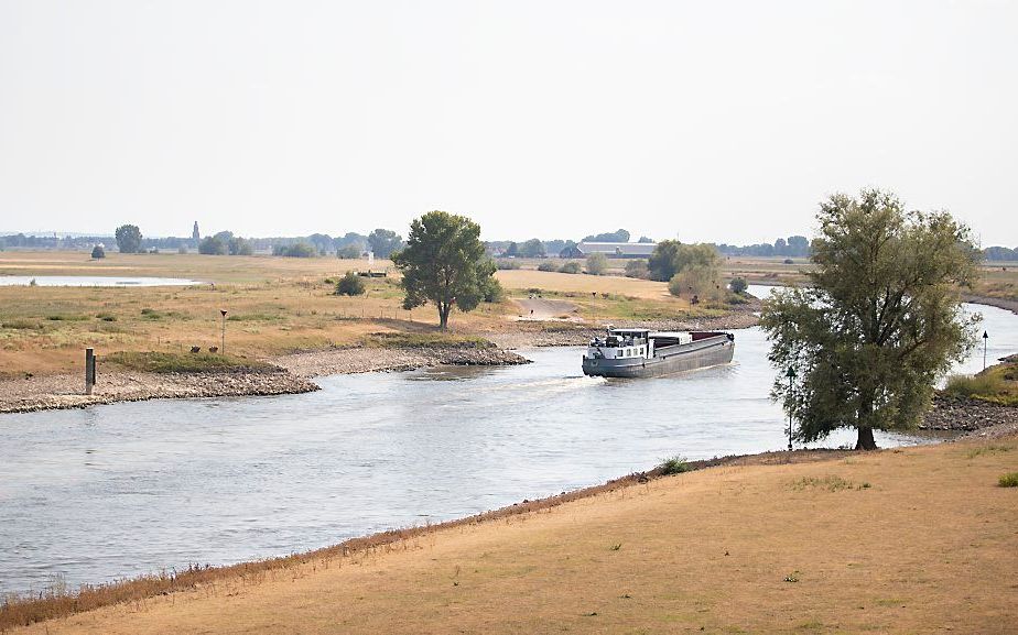 Een binnenvaartschip vaart over de laag staande IJssel bij Arnhem. beeld ANP