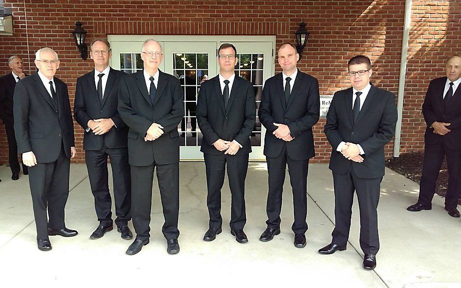 Docenten en studenten van de Theologische School in van de Netherlands Reformed Congregations in Grand Rapids. V.l.n.r. ds. A. H. Verhoef, ds. P. van Ruitenburg, ds. C. Vogelaar, E. M. Maljaars, J. J. Witvoet en H. de Leeuw. Op de achtergrond enkele curat