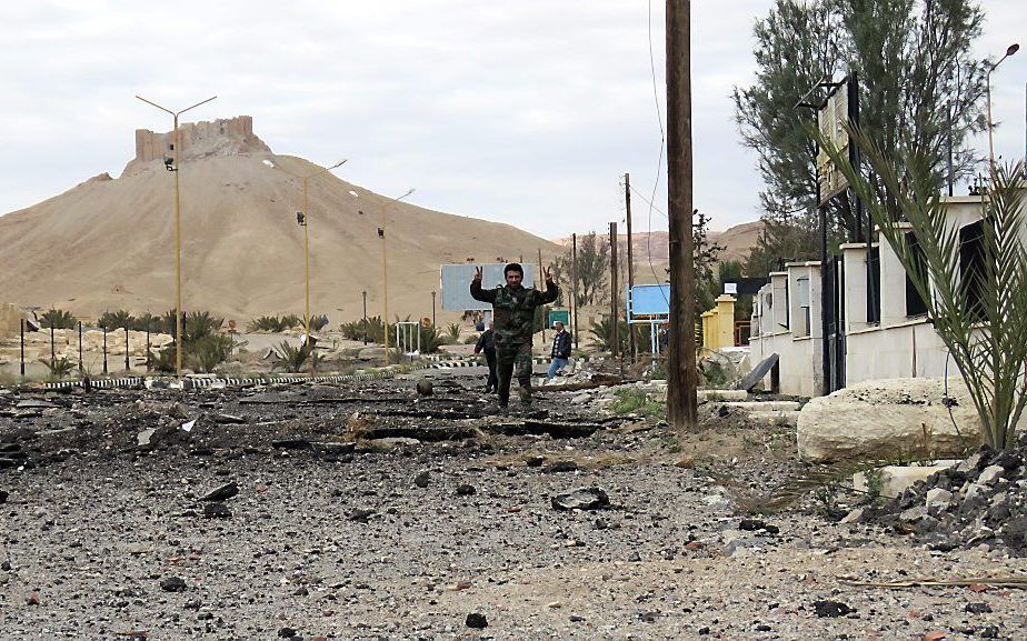 Syrische soldaat in het op IS heroverde Palmyra, dinsdag. beeld AFP, Stringer