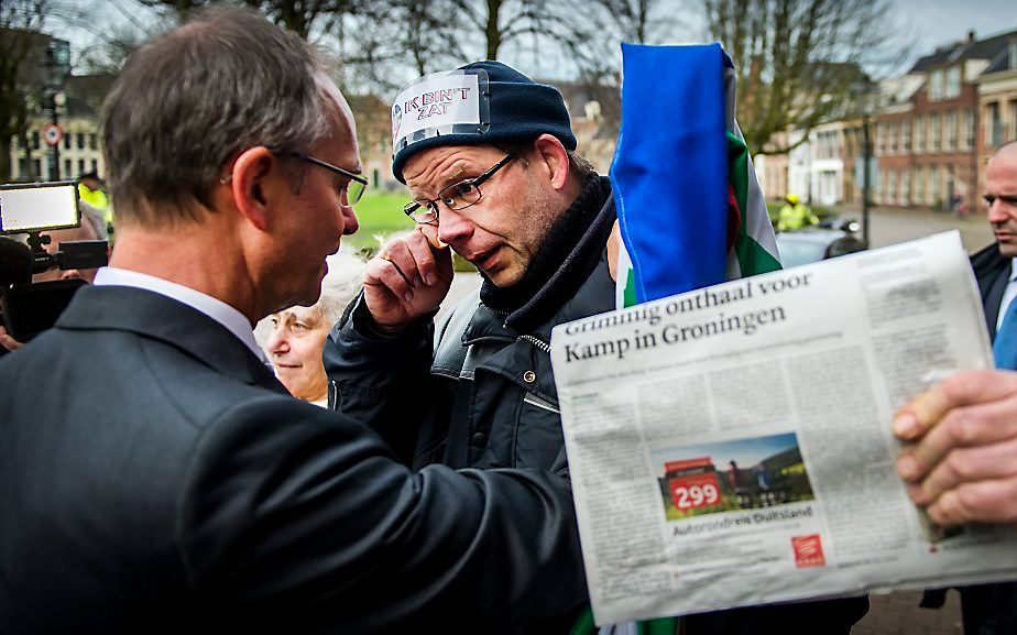 Minister van Economische Zaken Henk Kamp spreekt zaterdag bij zijn vertrek uit Groningen met een geëmotioneerde actievoerder. Foto ANP