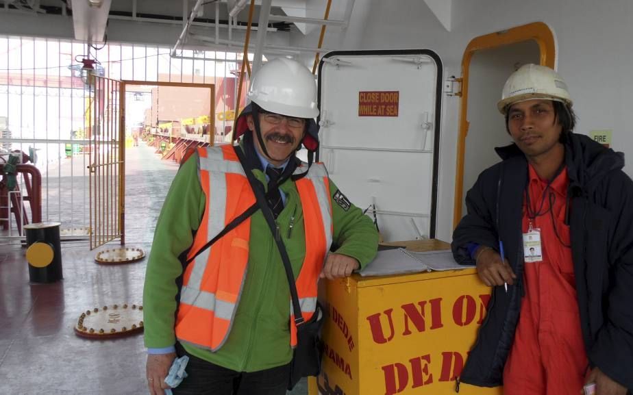 Diaconaal werker Rijk van Lent (l.) meldt zich in de Rotterdamse haven bij een Filippijnse matroos aan boord van een groot schip. beeld RD