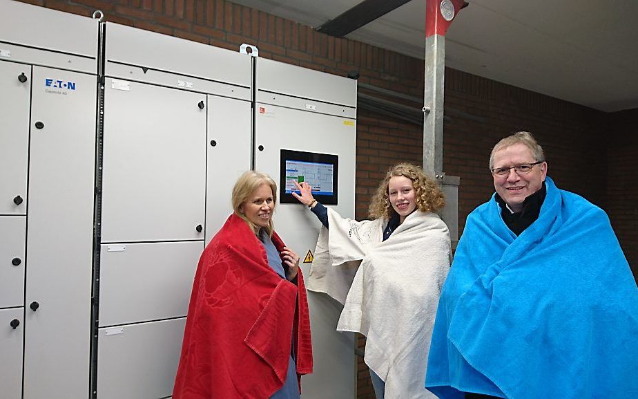 Heemraad Lida Schelwald-van der Kley (in het rood) en jeugdbestuurder Roos van den IJssel (in het wit) van het Waterschap Zuiderzeeland, en wethouder G. Post van de gemeente Urk. (blauw) openden dinsdag de eerste riothermie-installatie voor een zwembad. b