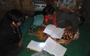 Een onderzoeker van Wycliffe Bijbelvertalers aan het werk in een bergdorp in Myanmar (Birma). beeld Wycliffe