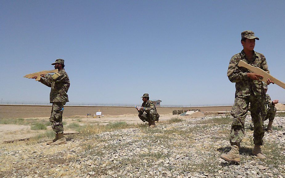 Afghaanse rekruten op oefening met houten geweren rond Camp Shaheen. beeld AFP