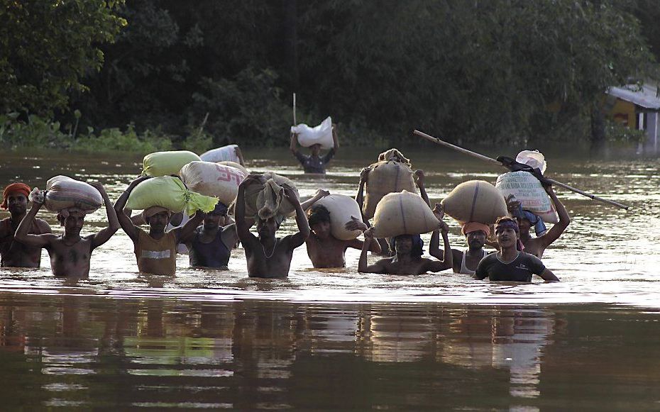 Indiërs op de vlucht voor het wassende water. Foto EPA